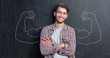 © Myvisuals - Young man against the background of depicted muscles on chalkboard
