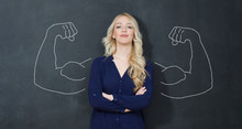 Young Woman Against The Background Of Depicted Muscles On Chalkboard