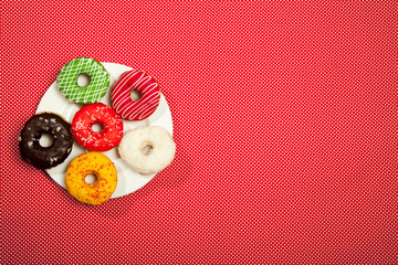 Wall Mural - Colorful donuts on a red table