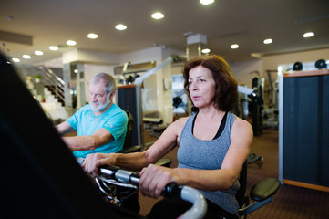 Wall Mural - Beautiful fit senior couple in gym doing cardio work out.