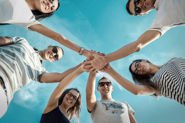 Group of friends on the beach under sunlight.