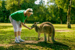Middle aged woman feeding a kangaroo at the zoo