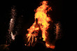 Traditional burning of Maslenitsa Scarecrow on seeing Russian winter on last day of Shrovetide in dark evening. Burning effigy on black background. Horizontal orientation