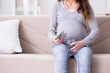 © Elnur - Pregnant woman sitting on sofa