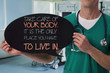 © dream@do - Male doctor holding health inspiration motivation quote on blackboard.