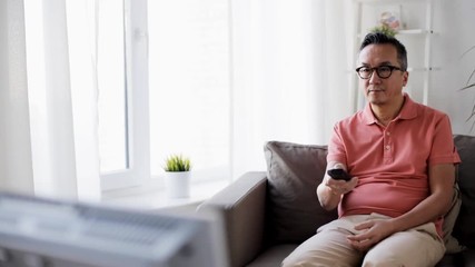 Sticker - man with remote control watching tv at home