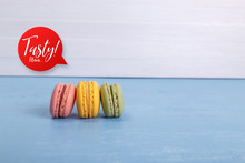 Macaroon Cakes. Different Types Of Macaron. Colorful Almond Cookies. Tasty Speech Bubble. On Blue Wooden Rustic Background.