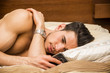 © theartofphoto - Handsome young man in bed typing on cell phone, sending text message or dialing number or maybe reading
