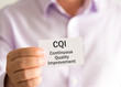 © stanciuc - Businessman holding a card with text CQI Continuous Quality Improvement