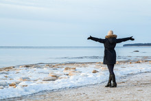 Young Woman At The Seaside Feels The Freedom In Winter Afternoon.
