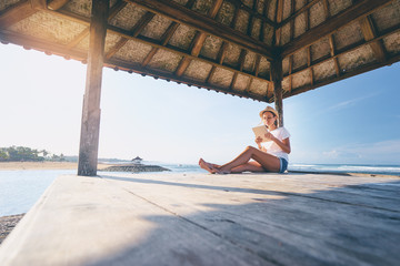 Wall Mural - Relaxed and cheerful. Work and vacation. Outdoor portrait of happy young woman using tablet computer on terrace near the sea.