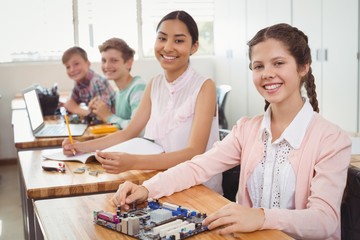 Portrait of smiling students studying in classroom