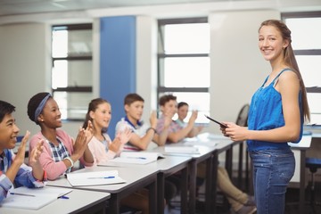 Students appreciating classmate after presentation in classroom