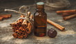 Essential cinnamon oil in a small bottle, ground cinnamon and cinnamon sticks on old wooden background
