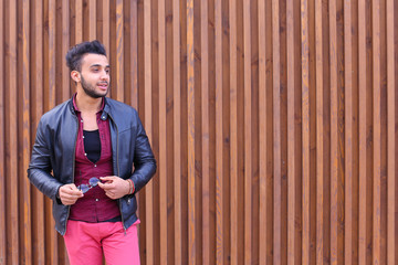 Wall Mural - Impressive Arabic Young Guy Examines And Corrects Glasses Jacket