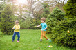 © pahis - Kids on Easter egg hunt in blooming spring garden. Children searching for colorful eggs in flower meadow. Toddler boy and his brother friend kid  play outdoors