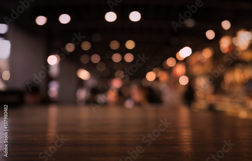 Fotografiet Empty wood table top on blur light gold bokeh of cafe restaurant in dark background/selective focus