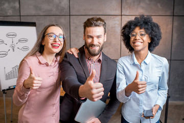 Wall Mural - Portrait of three happy multi ethnic coworkers together at the office