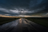Fototapeta Na sufit - Very Dark Wet Road During the Rain and the Sunset.  Stormy Road Horizon Landscape Weather Sunset  Rain  Danger Rural  Dramatic