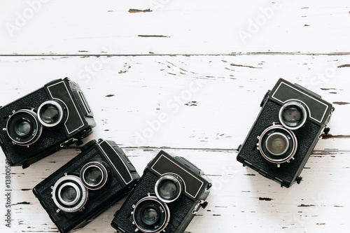 Stampe collection old vintage retro photo cameras on white wooden background