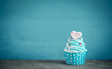 Cupcake With Sweet Heart Shape Of Marshmallow Against Blue Background
