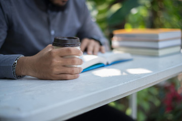 Wall Mural - Young hipster beard man drinking coffee while reading books in home garden with nature. Education concept.