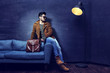 © MaxFrost - Handsome young man sitting on the sofa.