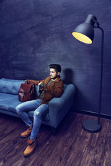 Handsome young man sitting on the sofa.