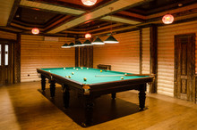 Room Billiards Decorated In Dark Wood With Low Lamps, Billiard Table With Green Cloth