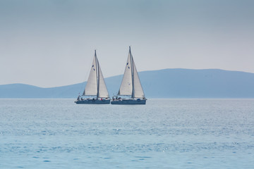  two same yachts sailing on the sea