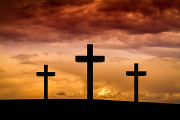 Wall Mural - Jesus Christ cross in Easter Friday evening on red, orange sky with dramatic clouds,dark sunset. Three wood crosses on Golgota Mountain. Calvary, Easter,Crucifixion, resurrection, Good Friday concept