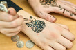 Gifted girl draws patterns by henna on the hands