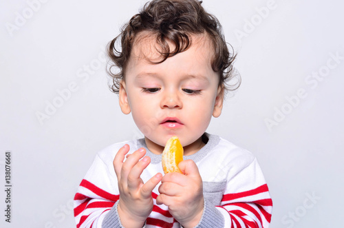 Portrait Of A Cute Baby Eating Orange One Year Old Kid Eating
