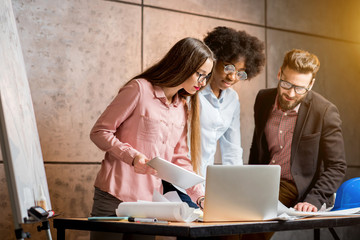 Wall Mural - Multi ethnic group of architects or designers working together on the architectural plans at the office