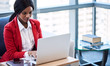© nakophotography - African American business woman busy looking at her computer screen while working on her notebook in the lounge of her business while seated a comfortable couch.