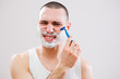 © djoronimo - Young man cut himself while shaving his beard.