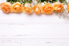 Frame Or Border  From Peach Color Roses Flowers On White Wooden Background.