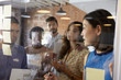 © Monkey Business - Businesswoman Writing Ideas On Glass Screen During Meeting