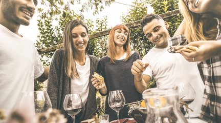 Wall Mural - Happy friends having fun drinking red wine eating at garden party - Friendship concept together at farmhouse vineyard winery - Focus on girl in middle with retro desaturated opaque contrast filter
