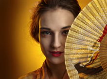 Young Beautiful Woman In Traditional Japanese Kimono With Fan