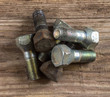 Old rusty and new bolts on wooden background