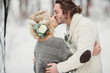 Beautiful stylish couple kissing in the winter park outside