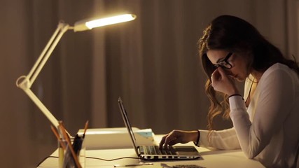 Wall Mural - tired woman in glasses with laptop at night office