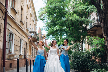 Canvas Print - The bride with bridesmaids walking along street