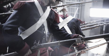 medieval soldier being shot in an attack surrounded by muskets in a revolutionary war