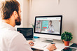 © GENETTICA - Young man in front of computer with healthcare videoblog on the screen.