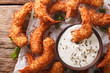 © FomaA - fried coconut shrimp close-up and a cream sauce on the parchment on the table. Horizontal top view