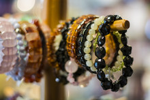 The Bracelets Hanging On A Wooden Stand.