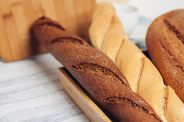 two baguettes on the board, a loaf