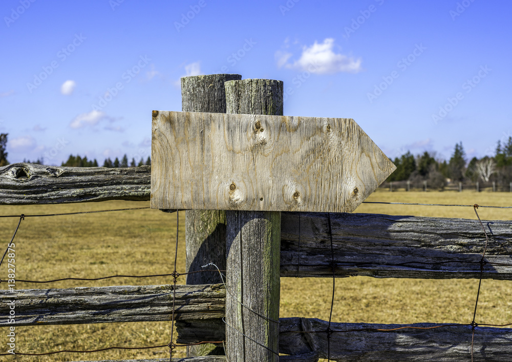 Rustic Arrow Sign Post Wooden arrow sign board on rustic fence post in outdoor background ...